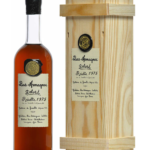 Bouteille de Bas-Armagnac Delord Millésime 1975 avec caisse en bois clair.